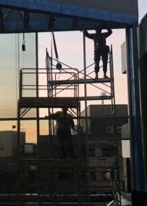 silhouettes of construction workers on scaffolding