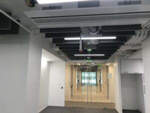 exposed industrial style ceiling in a hallway with sets of glass doors