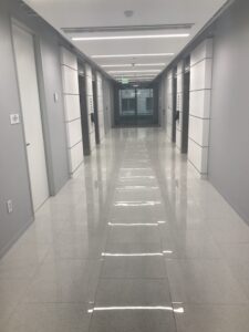 long hallway with linoleum flooring and multiple doors on either side