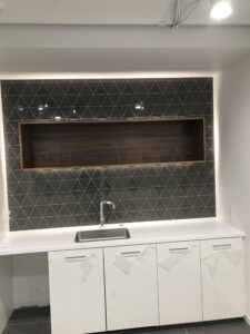 newly installed sink with a black tile backdrop and mirror