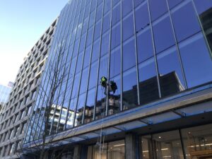 construction worker in a safety harness working on windows