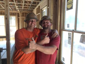 construction workers posing together in red t-shirts and smiling