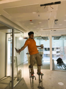 Ternion Builders employee ons stilts working on a ceiling