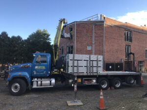 large truck delivering parts of a large exterior metal staircase to the ArachnidWorks building