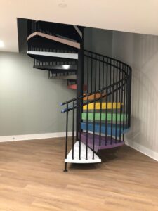 spiral staircase with rainbow steps in the ClearView Communities Wellness Center